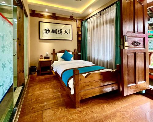 a bedroom with a bed and a window at Juxian Boutique Homestay in Lijiang