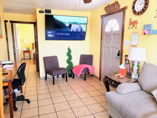 sala de estar con sofá y TV en la pared en White Sands Casita en Alamogordo