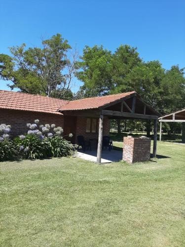 ein Gebäude mit einem Pavillon neben einem Hof in der Unterkunft Cabañas Sol de las Sierras in Tandil