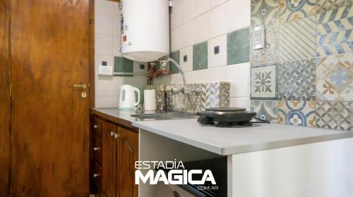 une petite cuisine avec une cuisinière et un évier dans l'établissement Cabañas en Malargue, à Malargüe