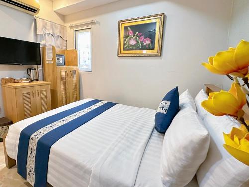 a bedroom with a bed with blue and white pillows at LUAN VU Hotel - Bui Vien Walking Street in Ho Chi Minh City