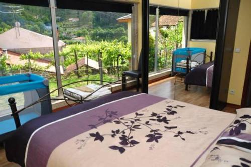 - une chambre avec un lit et une grande fenêtre dans l'établissement Casa da Mineira T2, à Gerês