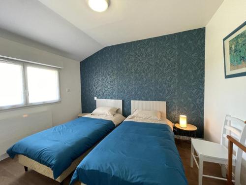 2 camas en una habitación con sábanas azules en Gîte Coutansouze, 3 pièces, 4 personnes - FR-1-489-478, en Coutansouze