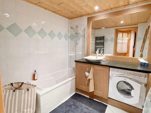 une salle de bain avec un lavabo et une machine à laver dans l'établissement Appartement cosy avec piscine, terrasse et parking, proche du centre et des commodités, arrêt ski-bus à 50m - FR-1-624-149, à Samoëns