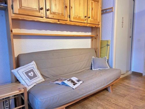 - un canapé dans le salon avec des placards en bois dans l'établissement Studio calme et fonctionnel, pied de pistes, pour 5 personnes, balcon sud – Risoul 1850 - FR-1-330-571, à Risoul