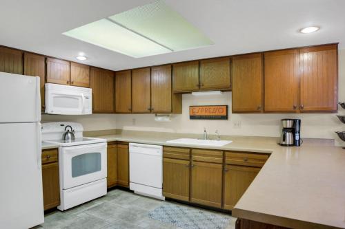 eine Küche mit weißen Geräten und Holzschränken in der Unterkunft PARK STATION 122 condo in Park City