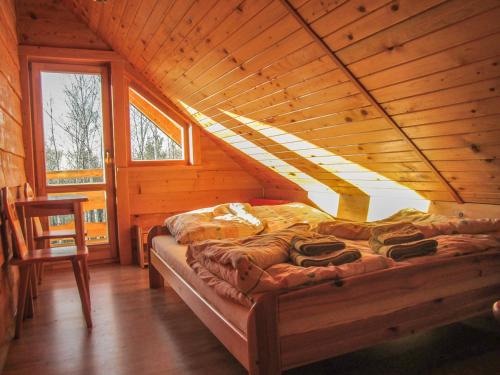 um quarto com uma cama num chalé de madeira em Chatka Włóczykija em Jamna