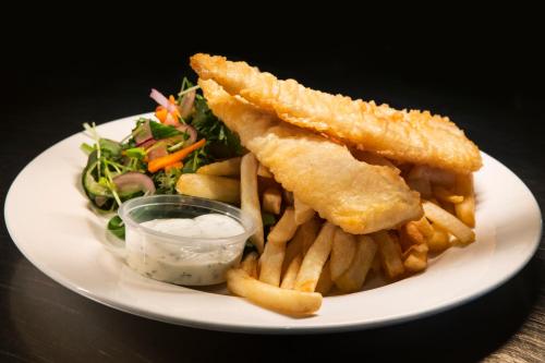 a plate of food with french fries and a salad at Nightcap at Macquarie Inn in Dubbo