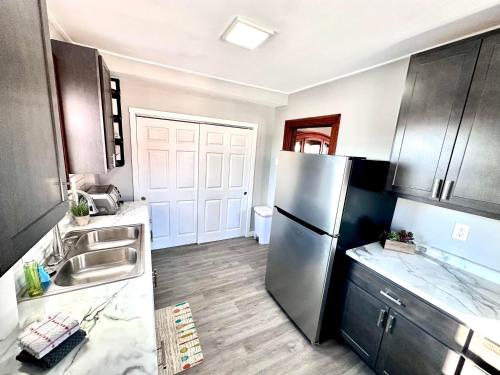 a kitchen with a stainless steel refrigerator and wooden floors at New 3 Bedroom City Escape in Saint Louis