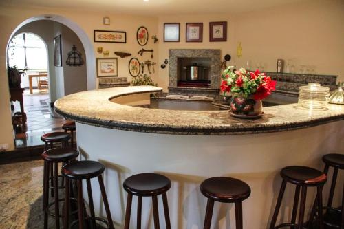 una grande cucina con bar con sgabelli di Villa da Esperança a Campos do Jordão