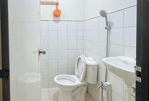RedDoorz @ Boondocks Cabins Resort في Dalumpinas Oeste: حمام صغير مع مرحاض ومغسلة