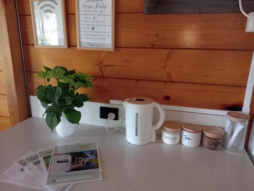 a counter top with a coffee maker and two mugs at Cosy in central Rotorua in Rotorua