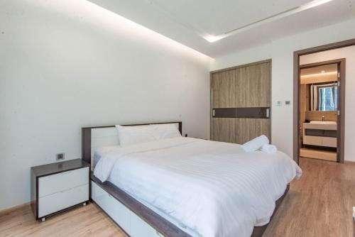 a bedroom with a white bed and a wooden floor at Vinhomes Metropolis luxury Hotel & Residence in Hanoi