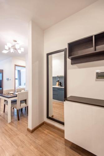 a kitchen and dining room with a table and a mirror at Vinhomes Metropolis luxury Hotel & Residence in Hanoi