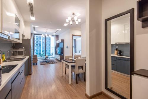 a kitchen with a table and a dining room at Vinhomes Metropolis luxury Hotel & Residence in Hanoi