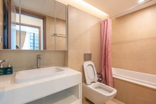 a bathroom with a sink and a toilet and a mirror at Vinhomes Metropolis luxury Hotel & Residence in Hanoi