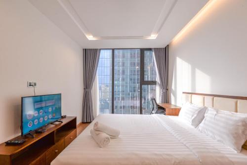a hotel room with a bed and a television at Vinhomes Metropolis luxury Hotel & Residence in Hanoi