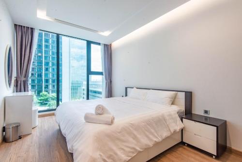 a bedroom with a large bed with a heart pillow on it at Vinhomes Metropolis luxury Hotel & Residence in Hanoi