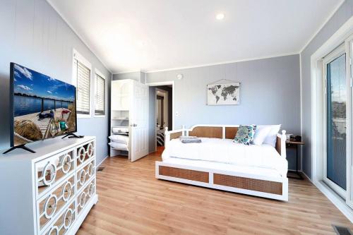 um quarto com uma cama e uma televisão em Chain O' Lakes Beach Penthouse with Lake Access em Ingleside