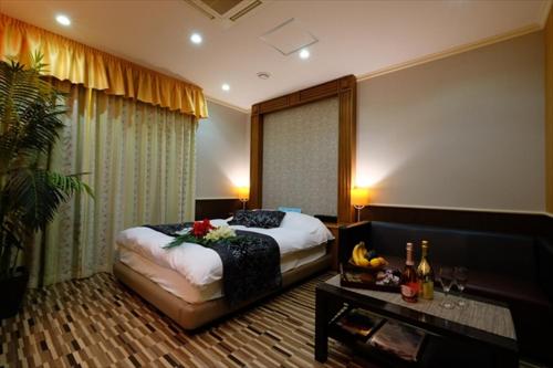 a hotel room with a bed and a table with bananas at 艶横浜町田店 adult only in Yokohama
