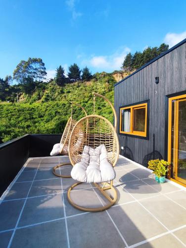 a rattan chair sitting on top of a patio at Departamento en Cocholgüe Tomé Concepción in Tomé