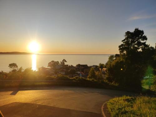 a sunset over the water with the sun setting at Departamento en Cocholgüe Tomé Concepción in Tomé