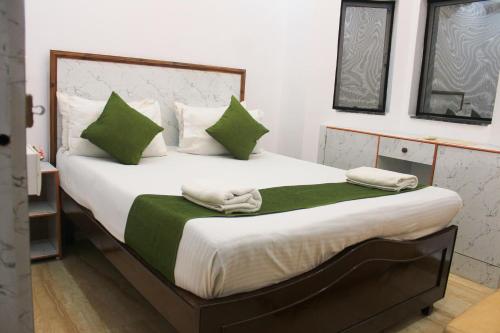 Un dormitorio con una cama grande con almohadas verdes y blancas en VILLA CASA SUMANJO (3BHK), en Calangute