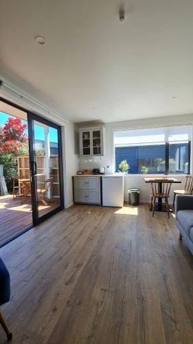 a large living room with a kitchen and a table at Beach Break Cabin 1 in Pohara