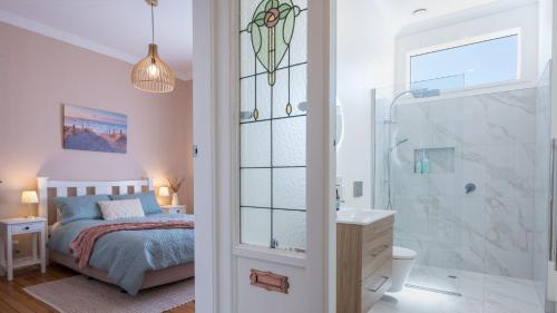 um quarto com uma cama e uma casa de banho com um chuveiro em Brook Nest em Nelson