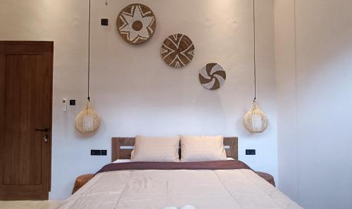 a bedroom with a bed and two clocks on the wall at Casa Benna - Salatiga in Salatiga