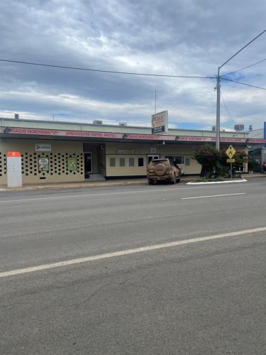 a car parked in front of a store on a street at Springsure Hotel Motel in Springsure