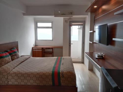 1 dormitorio con 1 cama y TV de pantalla plana en Sansan Room - Apartemen Gunung Putri Square, en Parungdengdek