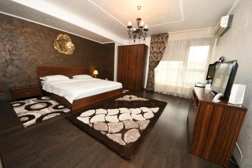 a bedroom with a bed and a flat screen tv at FLY - Regim Hotelier Galati in Galaţi