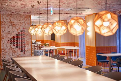 a dining room with tables and chairs and lights at lyf Ginza Tokyo in Tokyo