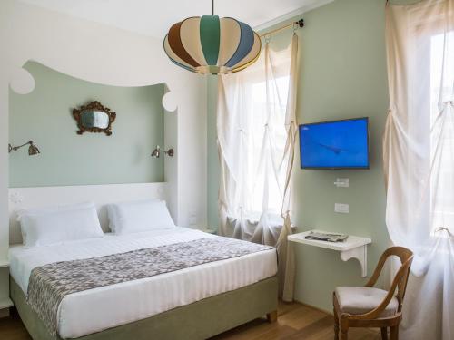 a bedroom with a bed and a chair and a tv at Rarity Suites in Rome