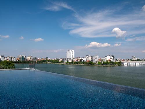 a large swimming pool with a city in the background at Elegant Mansion 88 in Hanoi