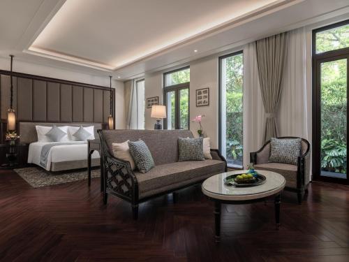 a bedroom with a bed and a couch and a table at Elegant Mansion 88 in Hanoi