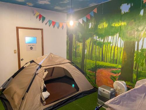 a tent in a room with a painting on the wall at MtFuji Guest House Kikkake in Fujiyoshida