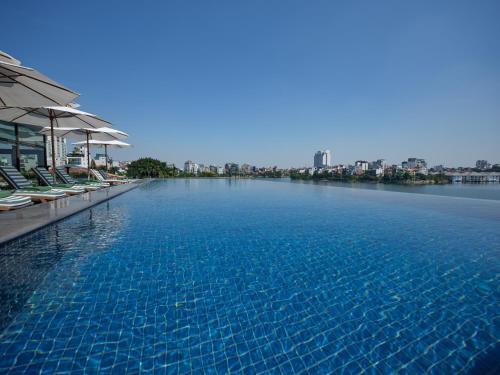 a large swimming pool with chairs and water at Elegant Mansion 88 in Hanoi
