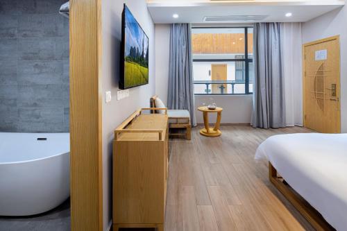 a hotel room with a bed and a bath tub at Qingshan Yuandai Boutique Homestay Yangshuo in Yangshuo