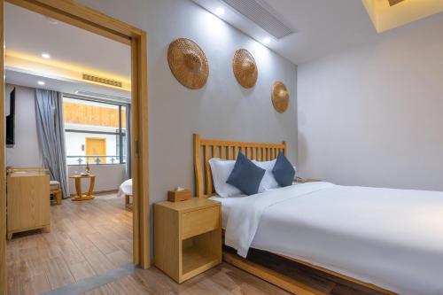 a bedroom with a large white bed and a mirror at Qingshan Yuandai Boutique Homestay Yangshuo in Yangshuo