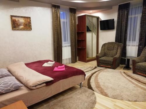 een slaapkamer met een bed met roze schoenen erop bij Панський Двір in Neslukhov