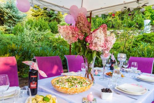 Una mesa con flores rosas y una pizza. en Villa Agnes Jacuzzi & Sauna, en Jasienica