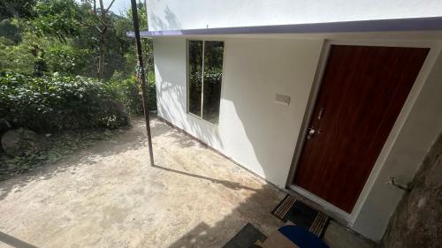 eine Glastür eines Hauses mit Fenster in der Unterkunft Homestay In Coorg Doddakallu Betta in Somvārpet