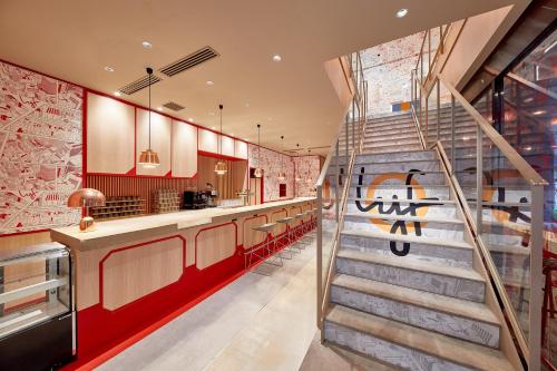 東京的住宿－lyf Ginza Tokyo，大堂设有螺旋楼梯的餐厅