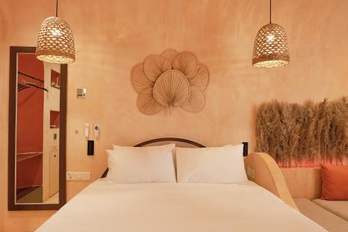 a bedroom with a white bed and two lights at Bstudio in APEC Mandala Mũi Né in Phan Thiet