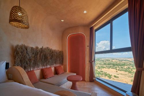 a bedroom with a couch and a large window at Bstudio in APEC Mandala Mũi Né in Phan Thiet