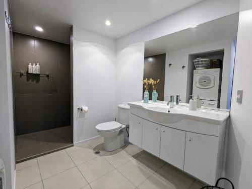 W łazience znajduje się umywalka, toaleta i prysznic. w obiekcie The Coastal Getaway w mieście Mount Maunganui
