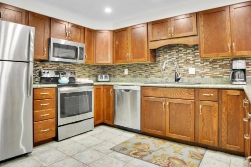 una cucina con armadietti in legno ed elettrodomestici in acciaio inossidabile di PARK STATION 113 condo a Park City