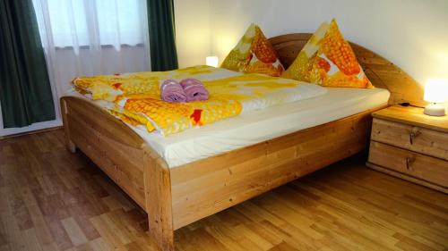 een slaapkamer met een houten bed met twee poppen erop bij Ferienwohnung Margit in Förolach